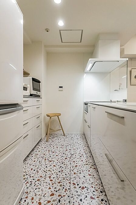 テラゾー柄のタイルが素敵！キッチン本体に加え、背面のカップボードや折れ戸、オープン収納など、キッチンまわりには豊富な収納が備わっています◎