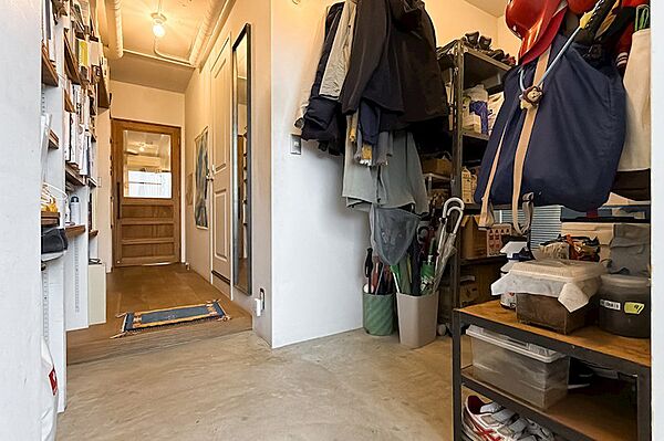 玄関に入ると、広々とした土間がお出迎え。左手には可動式の棚、右手には大型のラックやキャンプ用品などを置けるスペースが広がっています。