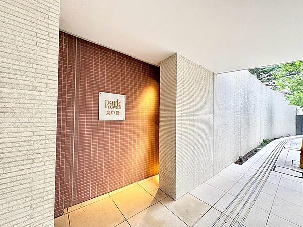 「PARK TOWER 東中野」の顔となるエントランスアプローチ。温かみのあるレンガ調と洗練された白い壁が、家族の帰りを優しく包み込みます。上質なデザインが日々の暮らしを彩ります。