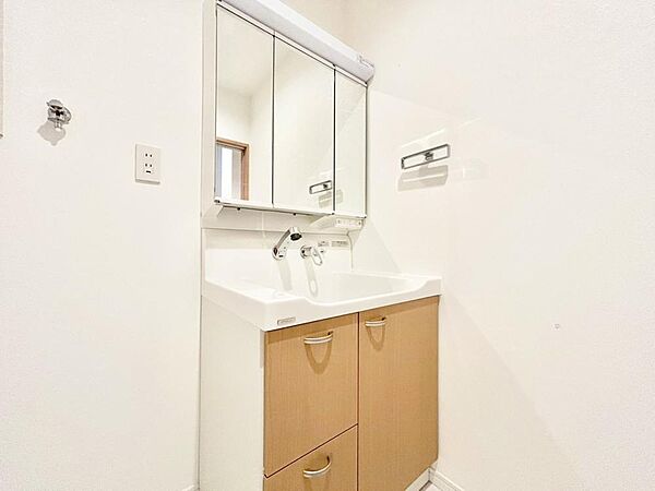 目線に合わせた三面鏡付洗面化粧台を採用しました。三面鏡の裏側には収納棚を確保。スキンケア用品やヘアケア用品などをすっきり整理できます。また収納棚を多く設けており、脱衣スペースを広く確保しております。