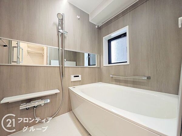 木目調のパネルが高級感を演出するバスルームで、日々の疲れを癒やす贅沢なひとときを過ごせます。広々とした鏡と機能的なシャワーが備わっており、細部までこだわり抜かれた上質な空間デザインが大きな魅力です