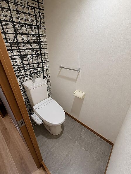 アクセントクロスがおしゃれな、清潔感のある温水洗浄便座付きトイレです。