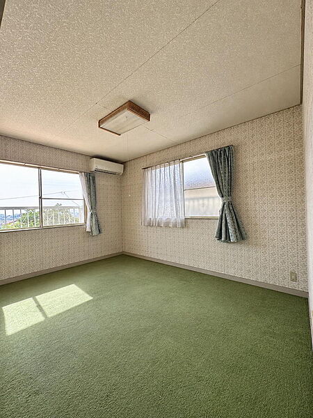 窓から光が差し込む、ゆったりとした洋室です。
