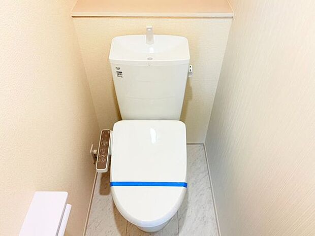 白を基調とした清潔感のあるトイレ空間。ペーパーや小物を置ける上部棚や手洗い器付きで、居心地の良い空間に仕上がっています。温水洗浄便座で季節を問わず快適にお使いいただけます♪