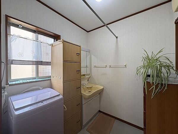 【洗面所】三面鏡付きの洗面台と窓付きの明るい洗面所です。
