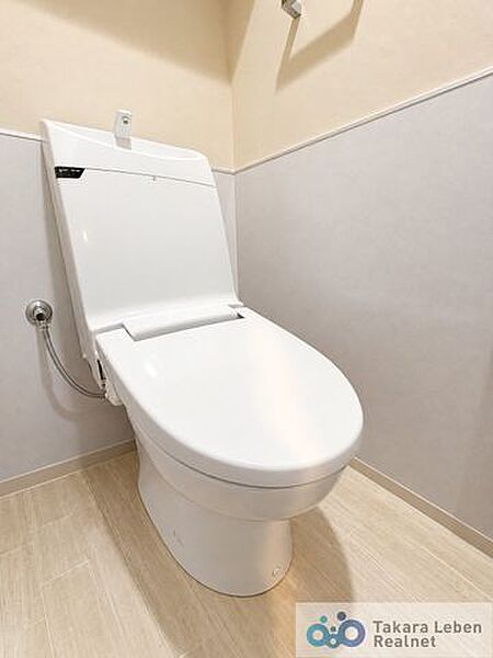ウォシュレット機能付きのトイレは壁掛けリモコンの上位グレードを採用。便座がスッキリした印象となり、限られた空間を広く見せる効果があります。