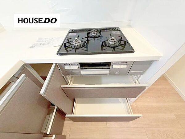 3口ガスコンロ＋グリル付きで同時調理もスムーズ。引き出し収納も豊富で、調理器具や食器をすっきり片付けられるキッチンです。