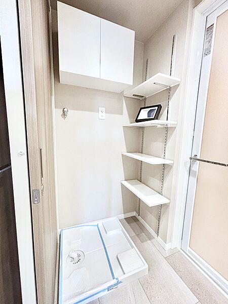 収納棚つきの洗濯機置き場。洗濯洗剤などの置き場に便利です！　