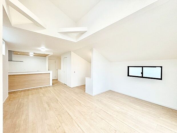 吹き抜けから明るい陽光が注ぎ、寛ぎの雰囲気に満たされるダイニング。