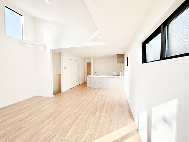 吹き抜けから明るい陽光が注ぎ、寛ぎの雰囲気に満たされるダイニング。