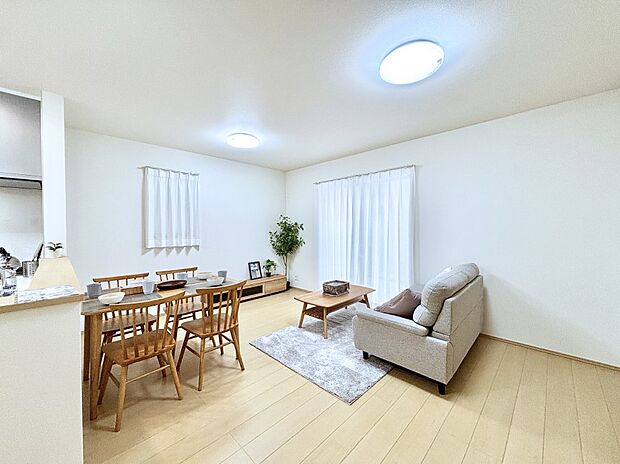 明るい陽光が注ぎ、寛ぎの雰囲気に満たされるリビング・ダイニング。 