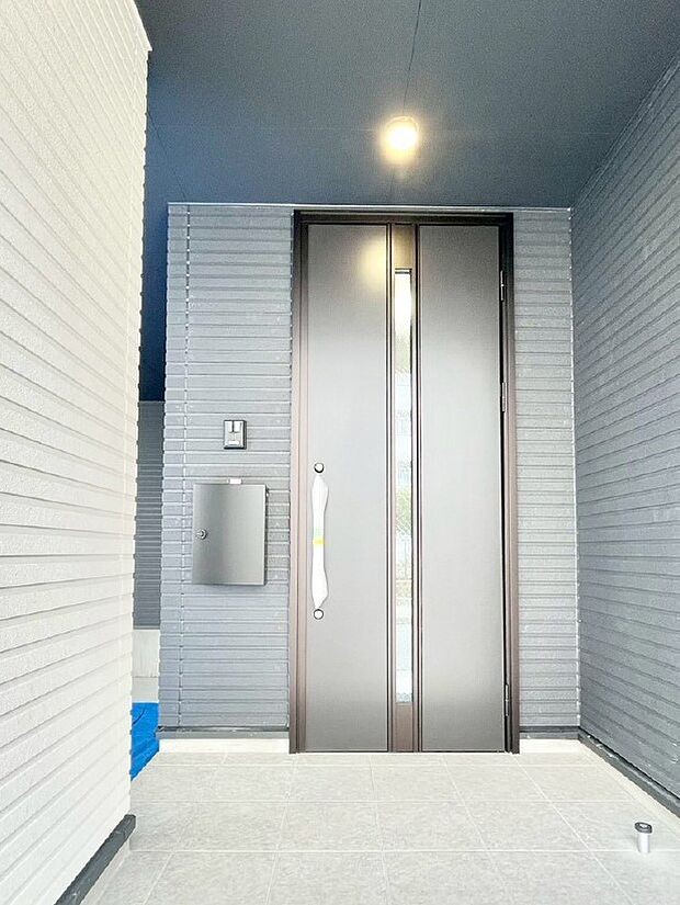 住まいの顔を演出する玄関ドアとシンプルデザインのポスト。