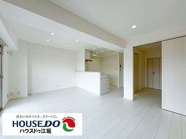 【広々18帖のLDK】白を基調とした開放感あふれる明るい住空間。対面式キッチンはご家族との会話も弾みます。隣接する洋室の扉を開放すれば、さらに大空間に！家具の配置も自由に楽しめます。