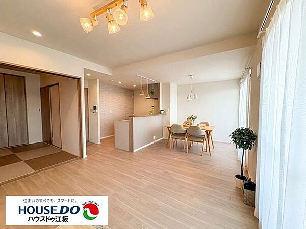 和室が隣接し、用途に合わせて一体利用も可能な広がりのあるリビングダイニング。木の温もりが感じられるナチュラルな木目調のデザインと落ち着いた照明演出が、家族でゆったり寛げる心地よい空間を創り出します。