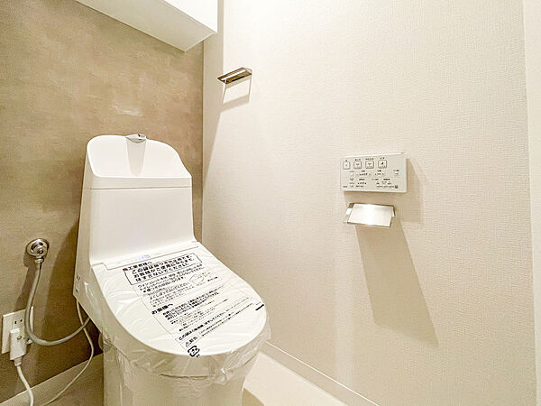白を基調とした清潔感溢れる温水洗浄機能付きのトイレです！スリムなデザインの便器は日々のお手入れがしやすく、綺麗な状態を保てます。壁面にはペーパーホルダーが機能的に配置されており、使いやすさも◎です！