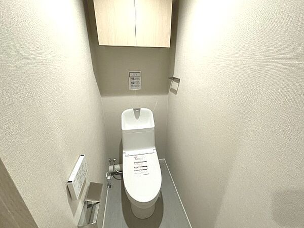 白を基調とした清潔感あふれる快適なトイレ空間です！上部には吊戸棚が備わっており、トイレットペーパーのストックや掃除用品をすっきり目隠し収納できます♪衛生的に保ちやすく気持ちよく利用できますね！
