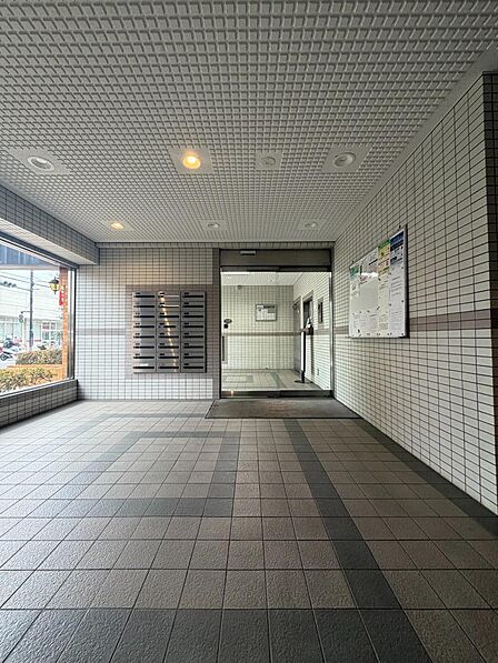 広々としたガラス張りの入り口から自然光が差し込み、明るく清潔感のあるエントランスになっています。