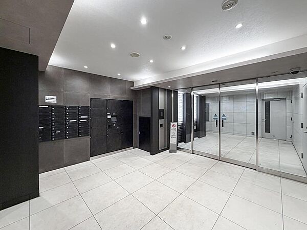 モノトーンで統一されたスタイリッシュなエントランスホール。不在時でも荷物が受け取れる宅配ボックスを完備しています