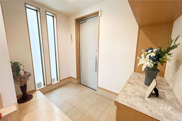 玄関。シューズクロークがあり、すっきりとした玄関で、高級感のあるベージュの色味を基調とした空間です。