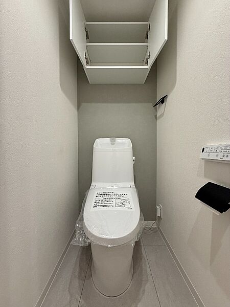 上部に吊戸棚式収納を配置した温水洗浄便座付トイレ