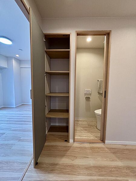 トイレの隣、廊下の使いやすい場所に収納棚があります。