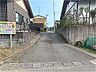 外観：砂利の手前の道路は舗装道路です。交通量も少ない場所です。