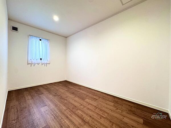 ウォームブラウンのフローリングと白壁が織りなす居室。柔らかな自然光が差し込み、主寝室や書斎としてゆったりくつろげる落ち着いた雰囲気が魅力の空間です。
