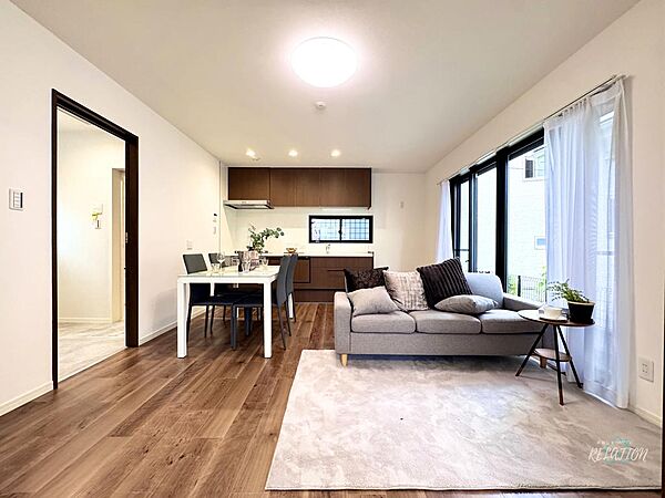 ダークブラウンの建具とフローリングが統一感を生むLDK。大きな窓から自然光が差し込み、明るく開放的な雰囲気のなかで毎日の食事や団らんをお楽しみいただけます。