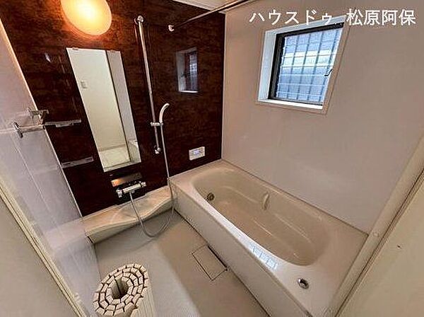 シックな木目調パネルが美しいバスルームには、ワンタッチで快適温度を保つ高機能な追焚システムを搭載。