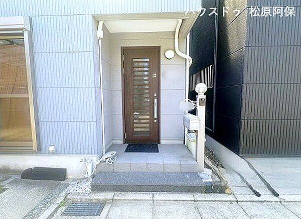 木目調（ダークブラウン）で、スリットガラスから採光ができる、現代的で落ち着いたデザインのドアです。