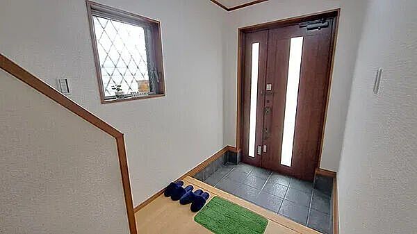 玄関木の温もりを感じる上品な玄関ドアが、家族やゲストを優しく出迎えます。小窓から自然光が入り明るい印象です。