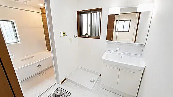 洗面室・浴室白を基調とした清潔感あふれるサニタリールーム。三面鏡タイプの洗面化粧台と洗濯機スペースをすっきりと配置。