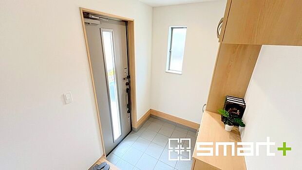 ~圧迫感のない明るい玄関~ ・窓に加えて玄関ドアのガラス部分からも穏やかな陽が入り、明るい玄関になります。 ・飾り棚としても演出できるコの字型のシューズボックスは大容量の収納力。