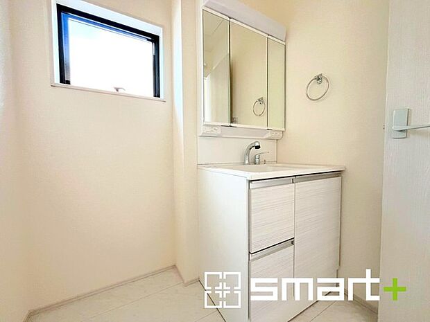 ～明るい洗面スペース～ ・窓から明るい陽が入り、気持ちよく朝の支度ができますね。 ・使い勝手の良い三面鏡タイプのシャワー付き洗面化粧台。鏡の裏に収納があるので洗面台周りもスッキリ。 