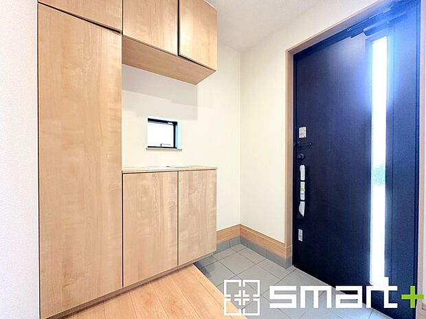 ～穏やかな陽が入る玄関～ ・窓に加えて玄関ドアのガラス部分からも穏やかな陽が入り、明るい玄関になります。 ・飾り棚としても演出できるコの字型のシューズボックスは大容量の収納力。