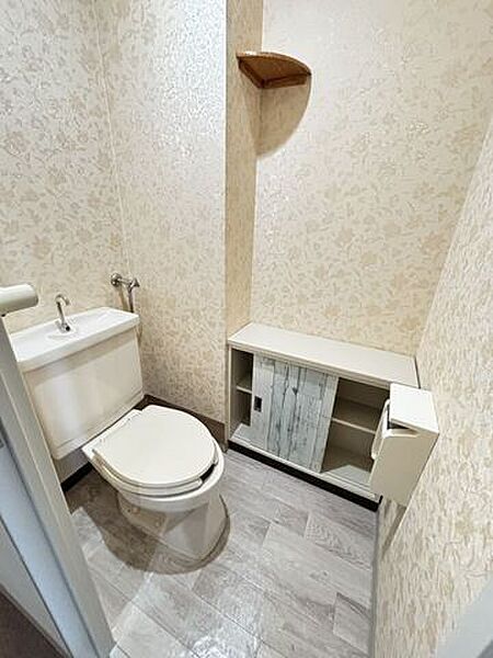 明るく清潔なトイレです。トイレットペーパーなどの収納スペースもあります。