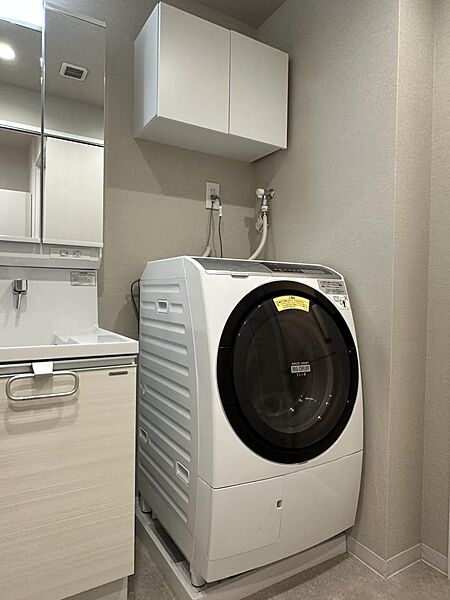 洗濯機置き場の上部には、扉付きの収納棚を標準装備