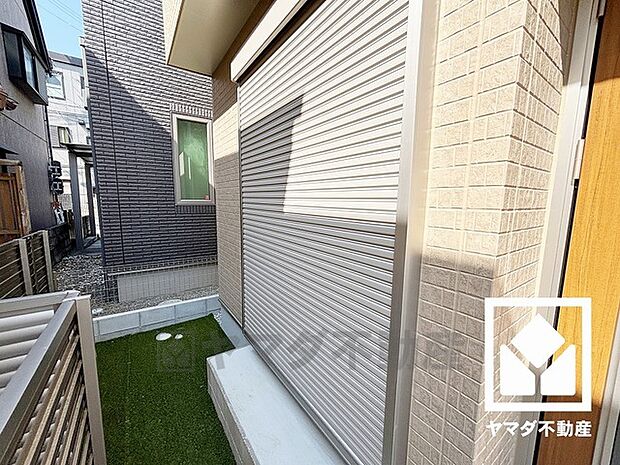 玄関横はガーデニングなどもお楽しみいただける人工芝のお庭スペースになっています。