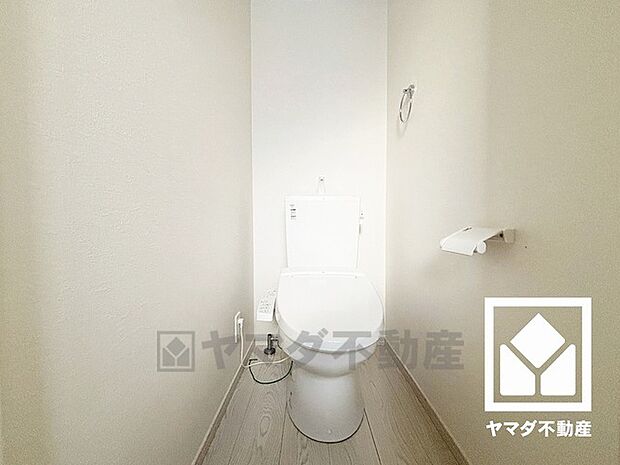 明るく清潔感溢れるトイレです。タオル掛けやペーパーホルダーが設置されています。