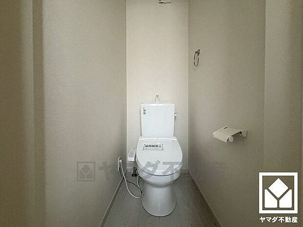 明るく清潔感溢れるトイレです。タオル掛けやペーパーホルダーが設置されています。