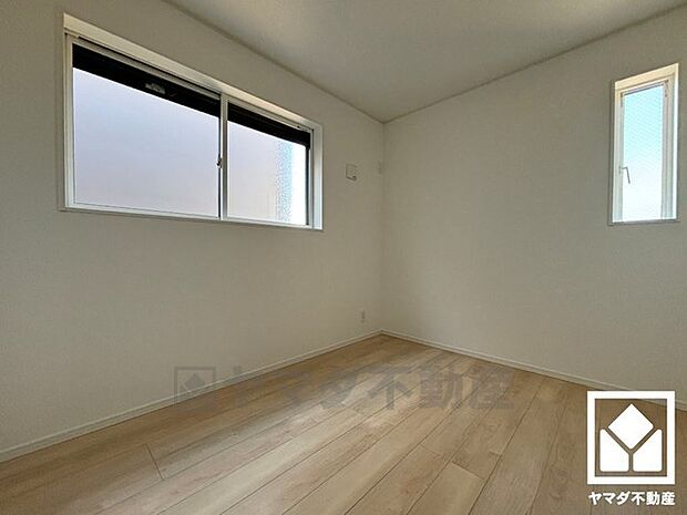 約5.1帖の洋室です。大きな窓からは明るい光が降り注ぎます。柔らかな光が差し込むお部屋で、快適で落ち着いた生活をお送りいただけます。