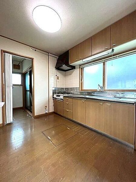 手元が明るい窓付きのシステムキッチン。上下に豊富な収納を備え、調理スペースも広々としていて実用的です。