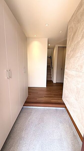 アクセントウォールと木目フロアが調和した、玄関空間です。