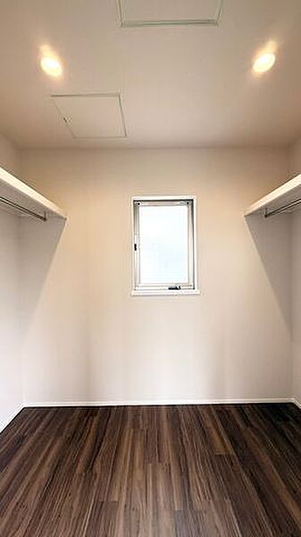 両サイドにハンガーパイプを備えたウォークインクローゼット。衣類を見やすく整理できます。