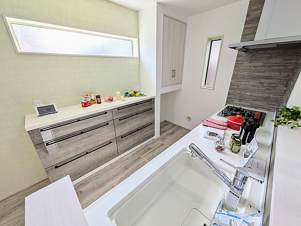 【施工例】キッチン背面には、家電収納置場が付いた専用のカップボード、横にはパントリー収納（下部はゴミ置場用のスペース）と豊富な収納をご用意したキッチンスペースです。