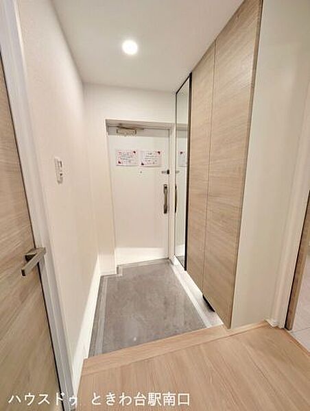 フルリノベーションで新しく生まれ変わった玄関ホール。木目調の建具が温かみを添え、大型の収納で玄関周りをすっきりと保てます。