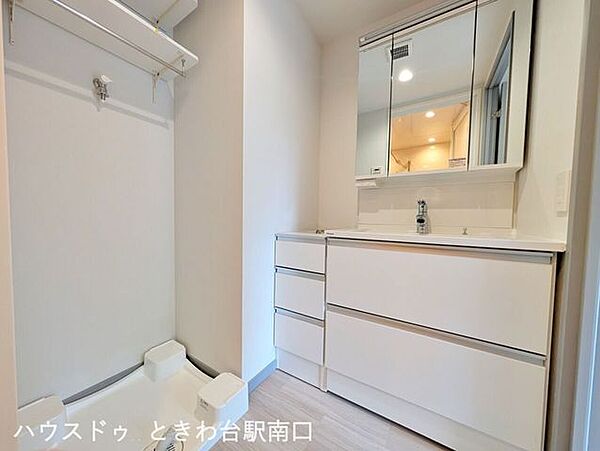 【洗面所】収納豊富な洗面化粧台と洗濯機置場を備えた、明るく機能的なサニタリースペースです。