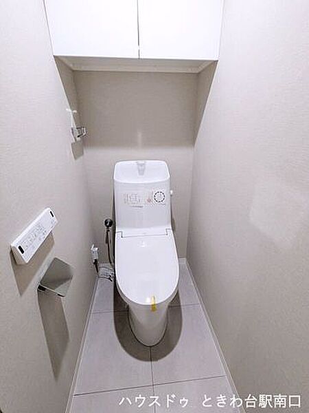 温水洗浄便座一体型のトイレは、新規交換され清潔にお使いいただけます。上部には便利な吊戸棚が備わっており、備品をすっきり収納可能。スッキリとしたデザインで心地よい空間です。
