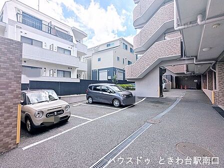 マンション敷地内の平置き駐車場です。スペースにゆとりがあり、入出庫もしやすい設計となっています。落ち着いたタイル貼りの外観とともに、日々のカーライフを支える共用設備が整っています。