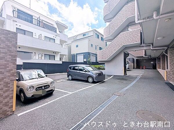 マンション敷地内の平置き駐車場です。スペースにゆとりがあり、入出庫もしやすい設計となっています。落ち着いたタイル貼りの外観とともに、日々のカーライフを支える共用設備が整っています。